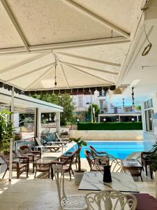Akçahan Apart Hotel في أنطاليا: فناء به طاولات وكراسي ومسبح