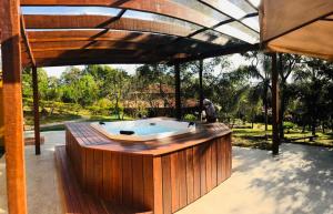 a hot tub on a patio under a roof at Pousada Spa Prana Lorien in Santo Antônio do Leite