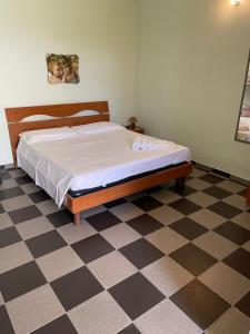 a bed in a bedroom with a checkered floor at Tenuta Innocenzi in Sanarica