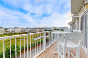 a balcony with a white table and chair on a porch at Lucayan 27 in Ocean City