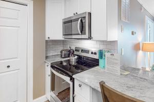 a kitchen with a stove and a microwave at Lucayan 27 in Ocean City