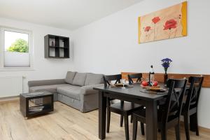 a living room with a table and a couch at Apartamenty Wiśniowy Sad by Renters in Kołobrzeg