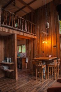 Habitación con cama elevada, mesa y sillas. en Proyecto COYAM, cabañas lofts, tinas privadas, sendero por el bosque en Villarrica