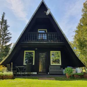 a black house with a thatched roof at Finnhaus Neubauer in Elbingerode