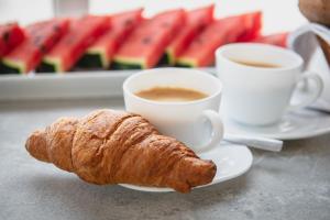 a plate with a croissant and two cups of coffee at Mon-Chery in San Ġwann