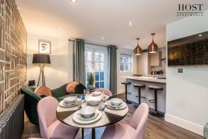 een woonkamer met een tafel en stoelen en een keuken bij Host & Stay - The Pilgrim Coach Houses in Liverpool