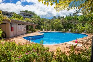 a swimming pool in a yard with chairs and trees at Wailea Sunset Condo - Ekolu #607 in Wailea