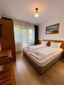 ein Schlafzimmer mit einem großen Bett mit weißer Bettwäsche in der Unterkunft Edelweiss Central Hotel in Bansko