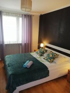 a bedroom with a large bed with a green blanket at Apartament M-3 in Częstochowa