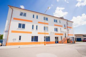 a white building with orange stripes on it at Apartmány Pokoj Zvolen in Zvolen