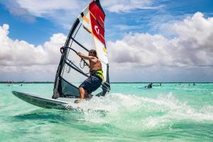 a man riding a wind sail on the ocean at Beach Studio Flaka at Lac Bay in Kralendijk