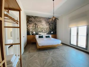 1 dormitorio con 1 cama y una pintura en la pared en Skyline - Penthouse with 50m2 private terrace and stunning views, en Cádiz