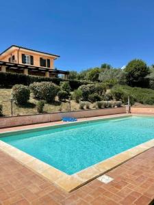 uma piscina em frente a uma casa em La Posta Di Bacco em Gualdo Cattaneo