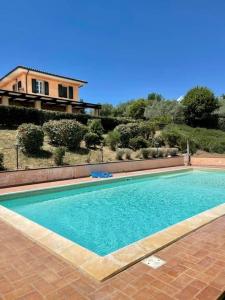 a swimming pool in front of a house at La Posta Di Bacco in Gualdo Cattaneo