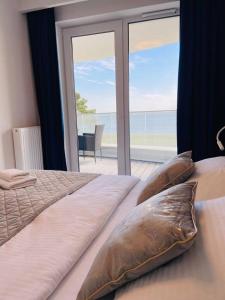 a bedroom with a bed with a view of the ocean at Rogowo Pearl Apartament Resko in Rogowo