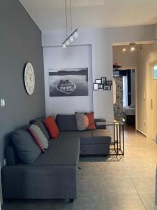 uma sala de estar com um sofá e um relógio na parede em Central Kalamata Cozy Apartment em Kalamata