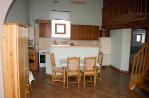 a kitchen with a table and chairs in it at Gesztenye Apartman in Makó