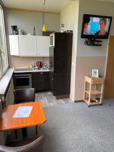 a kitchen with a table and a tv on a wall at Zimmervermietung Deichmann in Landscheide