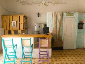 a bar with two purple chairs and a desk with a computer at Hostal Españolete in Santa Marta