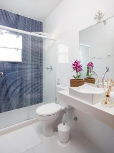 uma casa de banho com um WC, um lavatório e um chuveiro em Luar de Geribá em Búzios