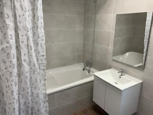 uma casa de banho com uma banheira branca, um lavatório e um espelho. em Casa Elena de Novelda em Novelda