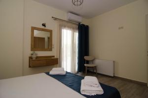 a bedroom with a bed and a mirror and a chair at L & A - GUEST HOUSE in Skala Potamias