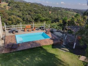a swimming pool in a yard with a wooden deck at Pousada Só Alegria in Mario Campos