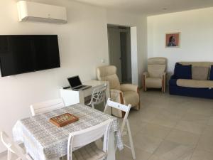 カネ・アン・ルシヨンにあるCANET LA Plageのテーブルと壁にテレビが置かれたリビングルーム