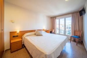 1 dormitorio con cama y ventana grande en Hotel Medes II en L'Estartit