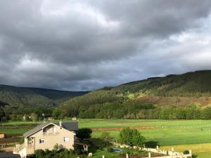 uma casa num campo com montanhas ao fundo em El Camino em Laza