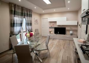a living room with a glass table and a television at LOFT ORTENSIA in Pompei