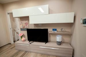 a living room with a flat screen tv on a entertainment center at LOFT ORTENSIA in Pompei