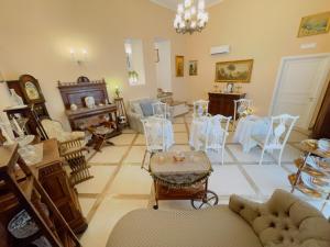 sala de estar con sillas blancas y mesa en B&B Coco's Apartments, en Meta