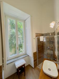 a bathroom with a sink and a window and a shower at Coco's Apartment in Meta