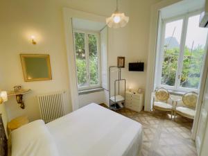 a bedroom with a white bed and two windows at Coco's Apartment in Meta