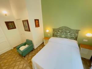 a bedroom with a large bed and a green chair at Coco's Apartment in Meta