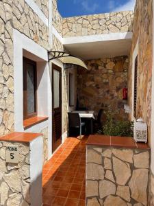 a stone building with a patio with a table at Villa Lucia in Lampedusa