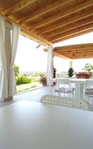 a patio with a white table and chairs on it at B&B Andrieddu in Telti