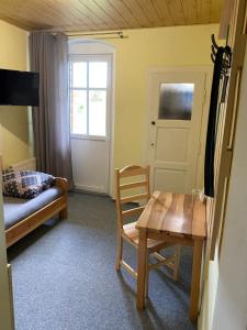 1 dormitorio con cama, mesa y puerta en Pension V Pohodě en Konstantinovy Lázně