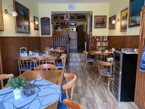 um restaurante com mesas e cadeiras de madeira e um bar em Pension V Pohodě em Konstantinovy Lázně