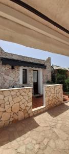 a stone house with a porch and a stone wall at Villa Lucia in Lampedusa