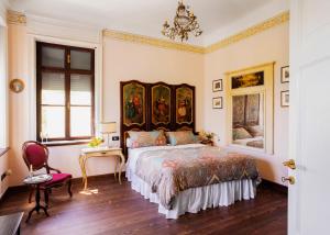 a bedroom with a king sized bed and a chandelier at Villa Maraldo 1927 in Orgnese +51 photos
