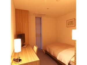 um quarto com uma cama e uma secretária com uma televisão em Pure Hotel - Vacation STAY 44183v em Yabu