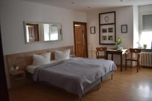 - une chambre avec un lit, une table et un miroir dans l'établissement Landgasthof Zur Sonne, à Enkirch