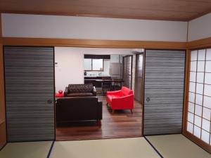 sala de estar con sofá y silla roja en ROYAL SUITE SAKAE - Vacation STAY 11483, en Nagoya
