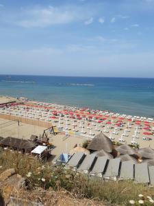 a beach with a lot of umbrellas and the ocean at Casa di Tiziana in Anzio