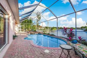 a swimming pool in a house with a glass ceiling at The Joint Venture - Cape Coral - Roelens Vacations in Cape Coral