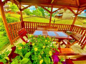 a wooden gazebo with a table and some flowers at Pokoje Gościnne u Marysi in Białka Tatrzańska