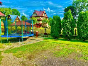 a playground in a yard next to a house at Pokoje Gościnne u Marysi in Białka Tatrzańska