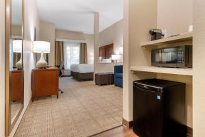 a hotel room with a bed and a microwave at Comfort Inn & Suites North Mankato in Mankato